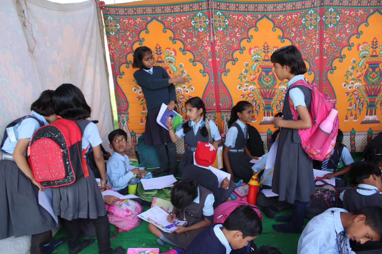 Students and facilitators at a creative activity tent