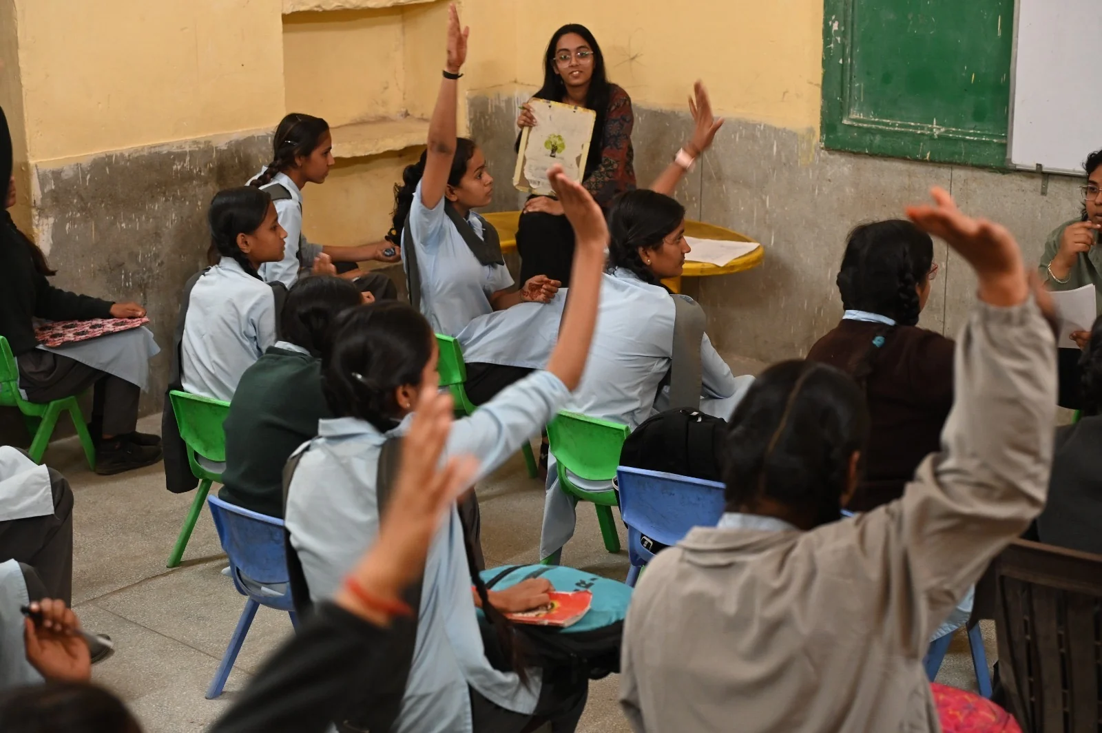 Students raising their hands in a classroom discussion